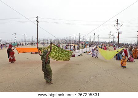 ALLAHABAD, UTTAR PRADESH, INDIA - FEBRUARY 07, 2013: Women put their sari out to dry on wind after ritual holy bathing in the Ganges river during the festival Kumbh Mela
