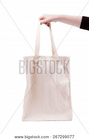 Mockup Of Female Hand Holding A Blank Tote Canvas Bag On White Background. Isolated Light Bag Made O