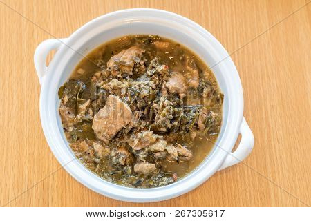 Thai Chamuang pork soup, pork with cowa leaf, thai east traditional food cuisine in white bowl on wooden background
