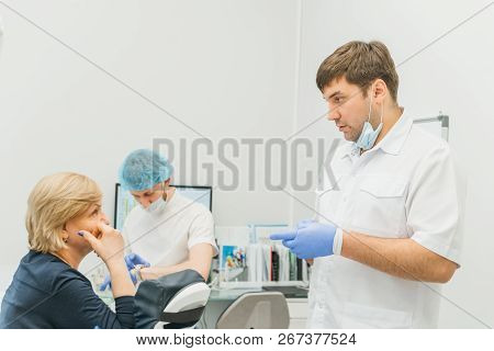 Doctor Used Microscope. Dentist Is Treating Patient In Modern Dental Office. Operation Is Carried Ou