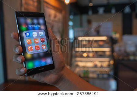 Chiang Mai, Thailand - June 09,2018: Man Holding Huawei With Icons Of E-commerce And Online Shopping