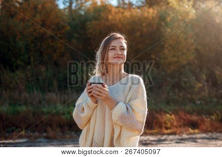 Beautiful Admiring Woman Drinking Hot Tea From Thermos Cup With Backligth Sun.