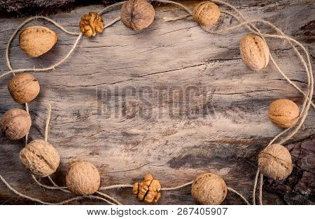 Walnuts Kernels With Twine On Wooden Log.
