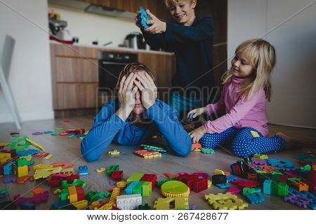 Kis Play With Toys Scattered All Over And Tired Exhausted Father