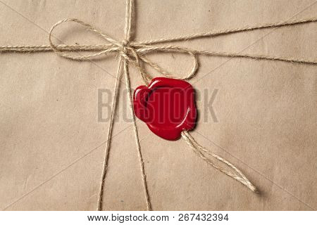 Rectangular Recycled Brown Paper Packaging Tied With Twine And Sealed With Red Sealing Wax.
