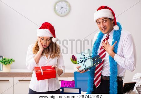 Colleagues exchaing christmas presents in office