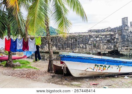 Portobelo, Panama  - May 28, 2016: Drying Laundry And A Fishing Boat In Portobelo Village, Panama