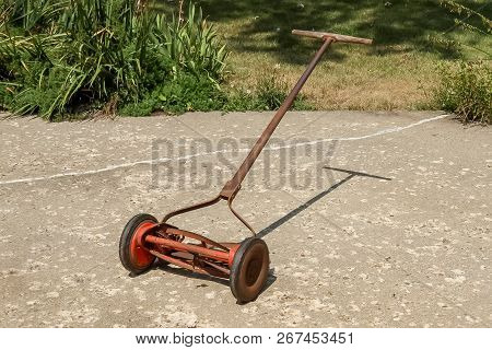 A Full View Of A Reel Lawnmower Before The Paint Was Removed