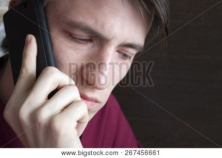 Young Guy Talking On The Phone, Looking Down