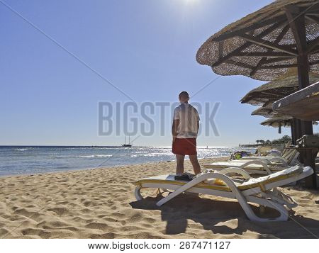 Egypt: A Young Man Stands On The Beach, Looks At The Sailboat And Dreams Of Adventure.