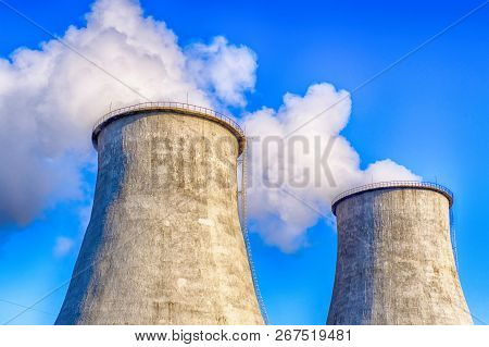 Two Big Smoking Pipes Of Powerplant. Heavy White Smoke On Blue Sky Background.
