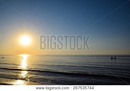 Sea Sunset. People Bathe In The Evening At Sunset In The Sea