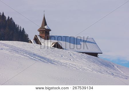 Roof of a chapel in the village of Stoos in the Swiss canton of Schwyz covered by snow in winter.
