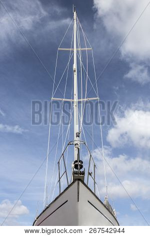 Sailboat Prow Over Blue Cloudy Sky. Low Angle Front View