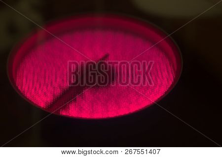 Red Circle F Electric Stove Powered Up, Red Hotplate Glows Red, Being On. Close Up.