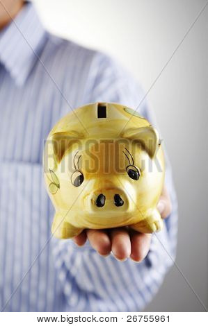 man showing a piggy bank on thew plain  background