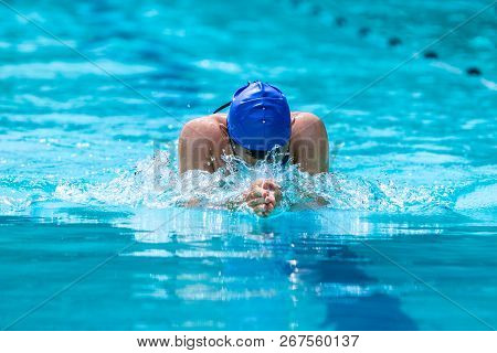 Male Swimmer Working On His Breaststroke  Swimming At A Local Pool On A Bright Sunny Day