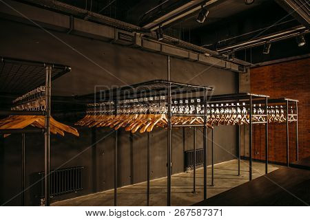 Wooden Hangers With Numbers In Dark Empty Cloakroom Or Checkroom Or Wardrobe.