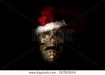 Evil Christmas Skull. Human Skull with a Santa Claus Hat. Isolated on black. Room for text. Evil Claus.