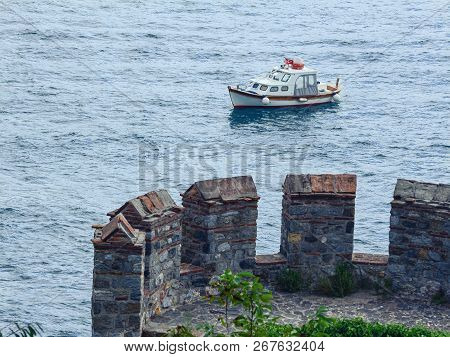 View From The Fortress Wall Of A Small Boat On The Sea Surface. Part Of The Tower Of The Famous Cast