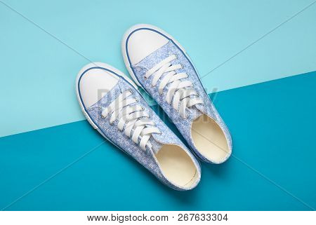 Fashionable Women's Sneakers With White Laces From The 80S On A Blue Pastel Background. Top View.
