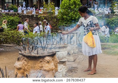 Kandy, Sri Lanka - July 19, 2016: White Clothed Buddhist Devotee Lights Incense Sticks At The Temple