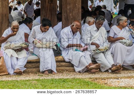 Kandy, Sri Lanka - July 19, 2016: White Clothed Buddhist Devotees Eat At The Grounds Of The Temple O