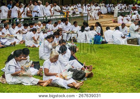 Kandy, Sri Lanka - July 19, 2016: White Clothed Buddhist Devotees Eat At The Grounds Of The Temple O
