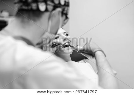 Dentist Carries Out Treatment Of The Young Girl With Braces In Dental Office.