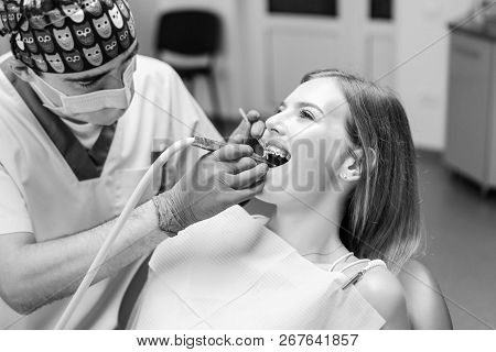Dentist Examine Female Patient With Braces In Denal Office.