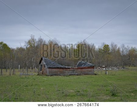 Dreary Abandoned Collapsed Farm Shed With Cloud Skies In Northern Minnesota