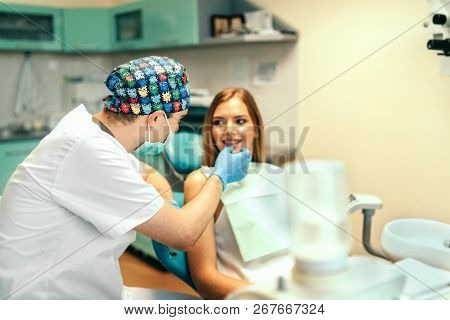 Dentist Examine Female Patient With Braces In Denal Office.