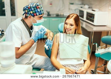 Dentist Examine Female Patient With Braces In Denal Office.
