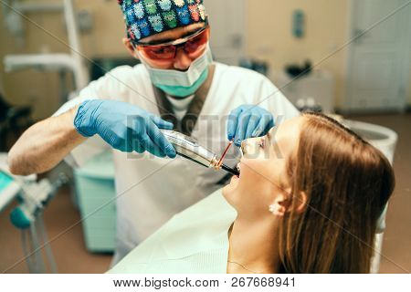 Dentist Carries Out Treatment Of The Young Girl With Braces In Dental Office.