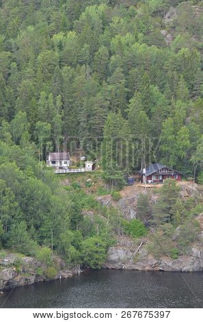 Typical Swedish nature and houses on the shore of the fjord. View from the high bridge over the fjord. The border of Norway and Sweden.June 18,2018.Near the town Selater,Sweden