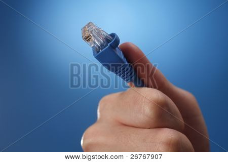 มือมนุษย์ที่ถือครองการใช้สายเคเบิลเชื่อมต่ออินเทอร์เน็ต