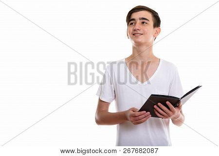 Studio Shot Of Young Happy Persian Teenage Boy Smiling And Holdi