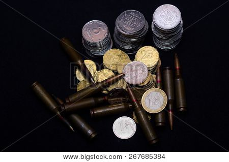 One Euro, Russian Ruble And Small Ukrainian Coins With Rifle Military Ammo On Black Background. Symb