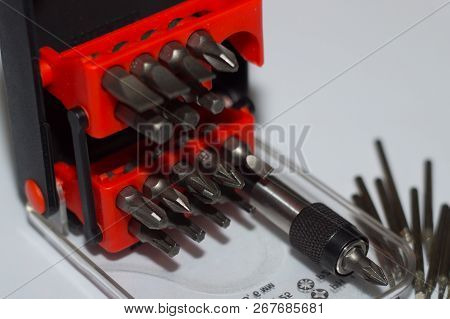 Bits Holder In Box And Many Tool Bits On White Background. Close-up View. Red Element In Plastic Box