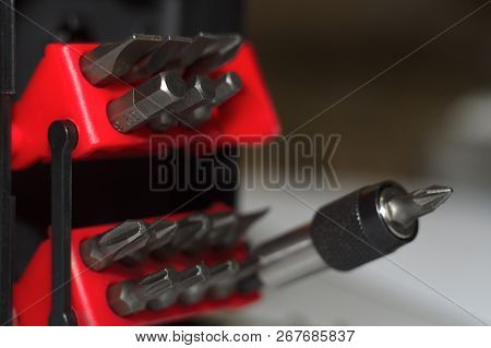 Bits Holder In Box And Many Tool Bits On White Background. Close-up View. Red Element In Plastic Box