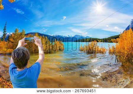 Autumn flood of Abraham lake. Artificial Abraham lake reflects the golden foliage of aspen and birches. Concept of active, ecological and photo tourism
