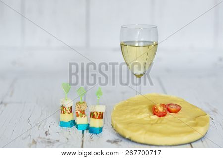 Glass Of White Wine, Polenta With Cherry Tomato And Chese Canapes On A Wooden Background