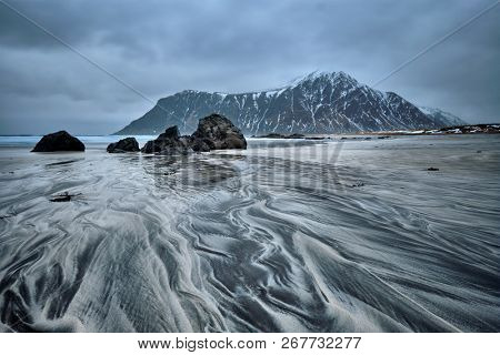 Rocky coast of fjord of Norwegian sea in winter. Skagsanden beach, Lofoten islands, Norway