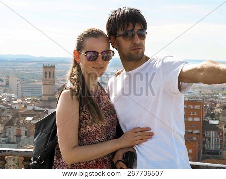 Loving Couple Of Tourists On A Viewing Platform In Tarrega, Catalonia, Spain. An Attractive Tall Dar