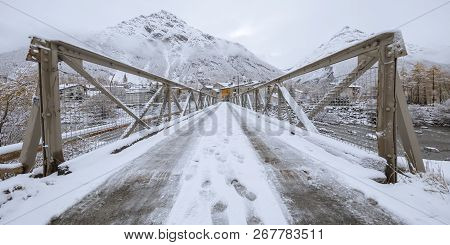 Foot Prints In The Snow On A Bridge Leading To The Village, Bessans, France 2018.