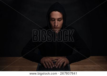 Portrait Of Hacker In Black Hoodie Using Laptop, Cuber Security Concept
