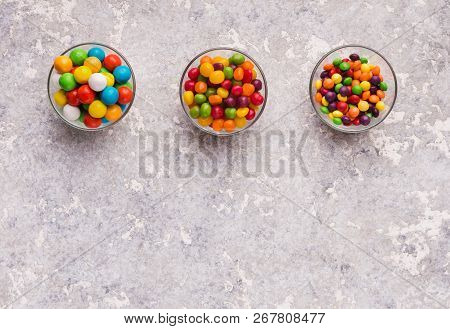 Assorted Bon Bon Candies In Bowls On Concrete Background, Copy Space