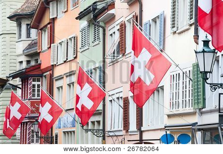 Gamle gade Augustinergasse i Zürich dekoreret med schweiziske flag