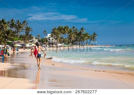 Mirissa Beach, Sri Lanka - JAN 3, 2017:  Tourists walking on the sand while enjoying the view across the wonderful beach of Mirissa on Jan 3, 2017. Sri Lanka.