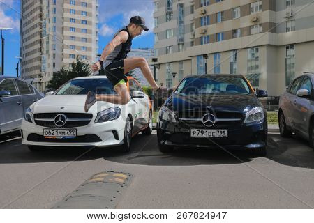 MOSCOW - JUN 20, 2018: Man (with MR) jumps near two Mercedes Benz cars of Moscow carsharing company You drive, carsharing is system of short-term car rental